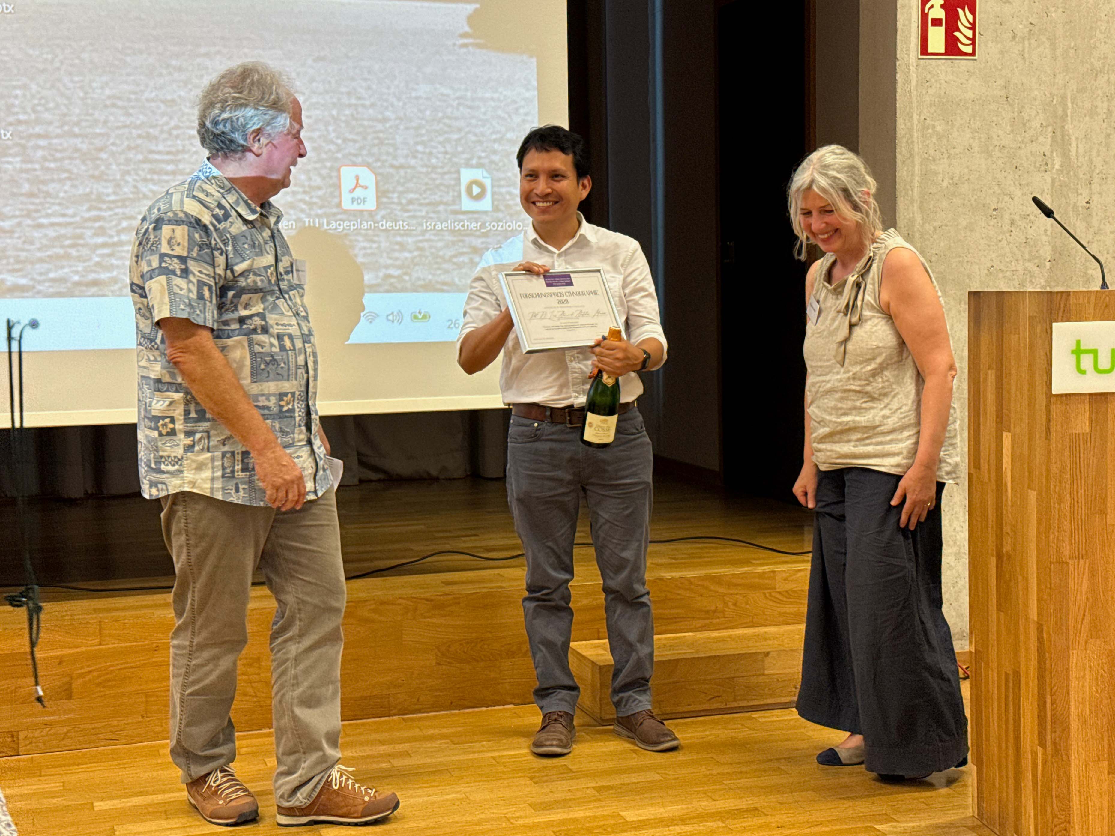 Luis Bastidas, en la mitad, junto a la Prof. Dr. Angelika Poferl, Universidad Técnica de Dortmund, y el Prof. Dr. Christoph Maeder, profesor emérito de la Universidad de Formación Docente de Zúrich.